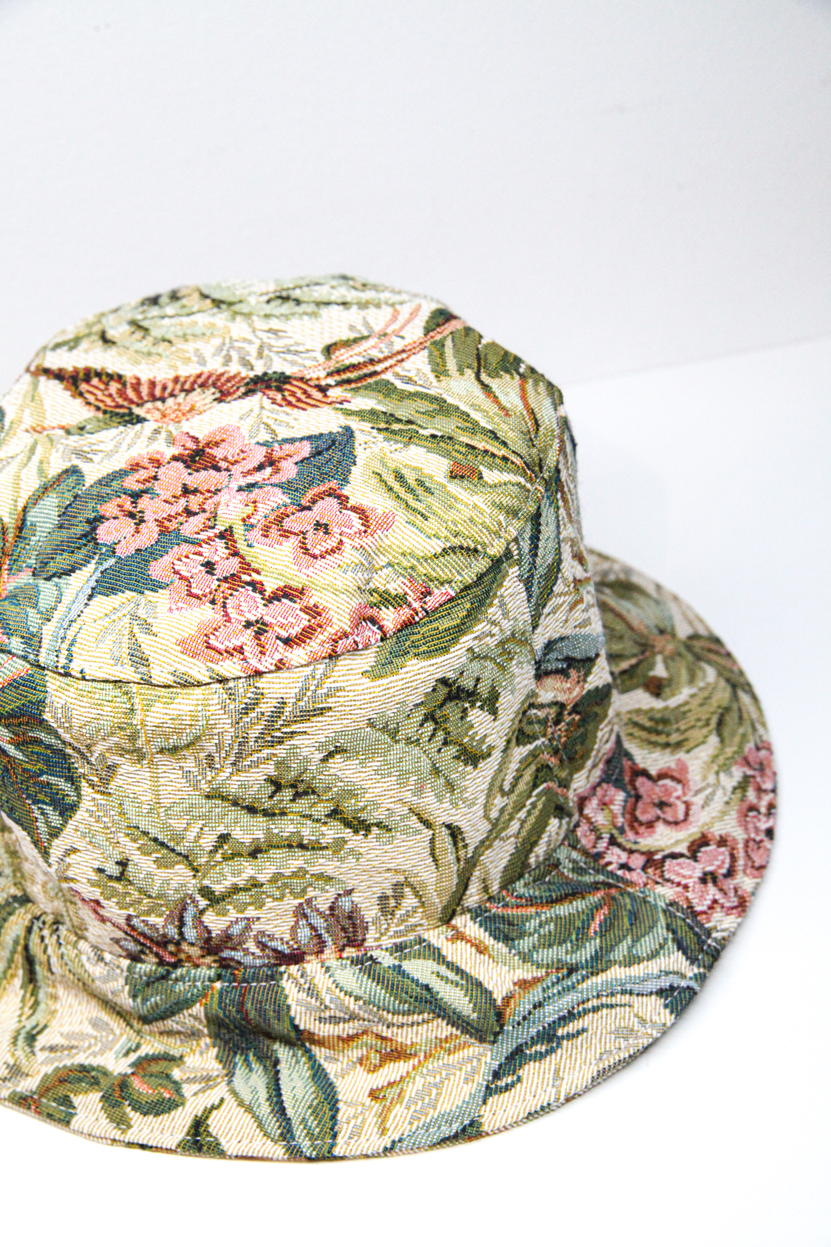 Green bucket hat with tropical flower pattern and exotic birds