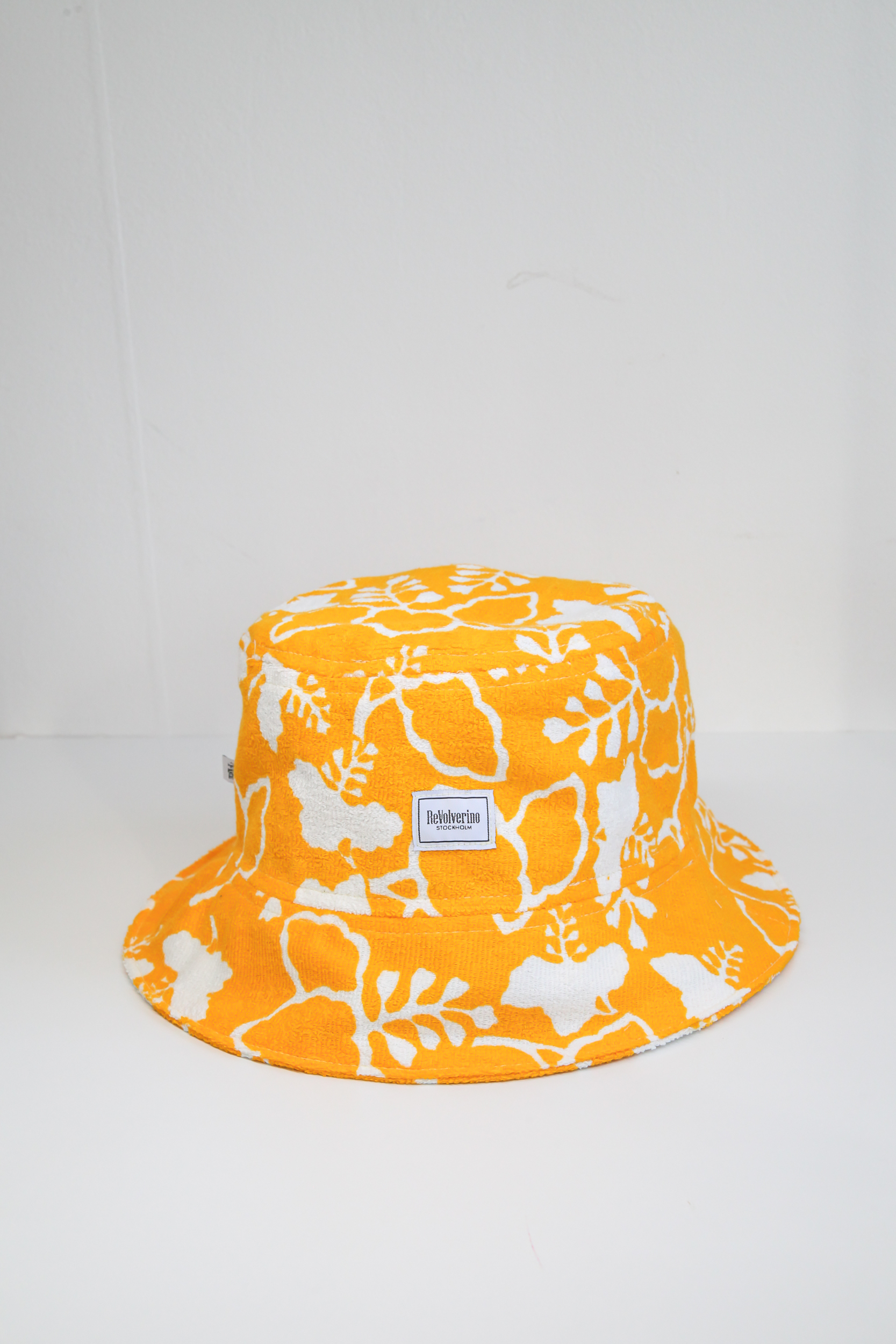 Yellow terry summer bucket hat with white floral tropical pattern