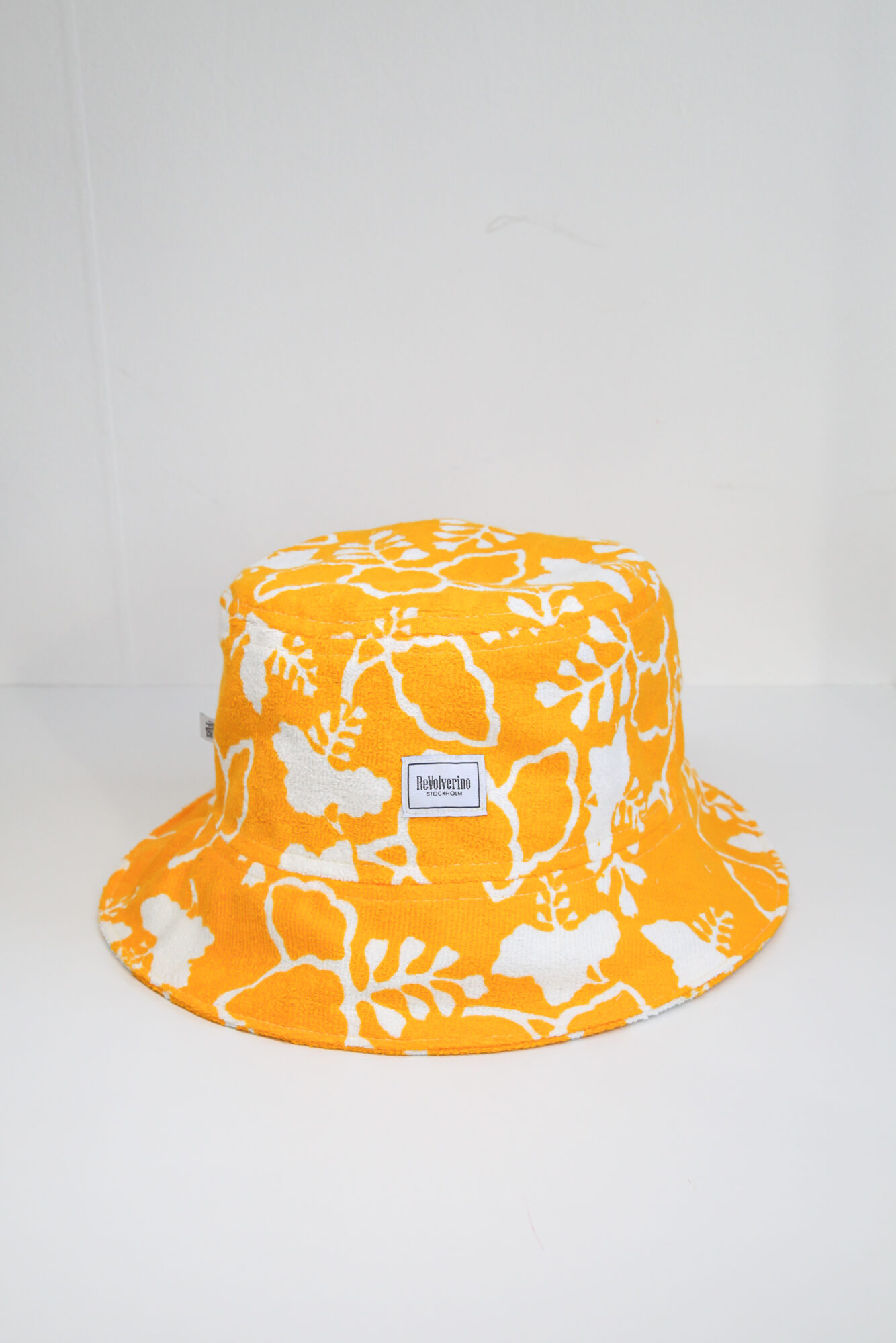 Yellow terry summer bucket hat with white floral tropical pattern