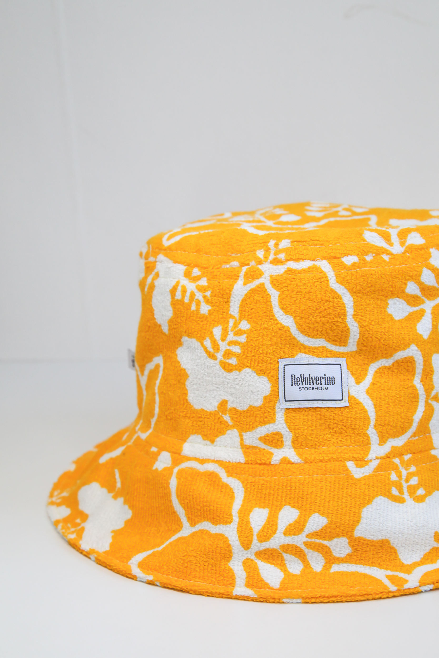 Yellow terry summer bucket hat with white floral tropical pattern