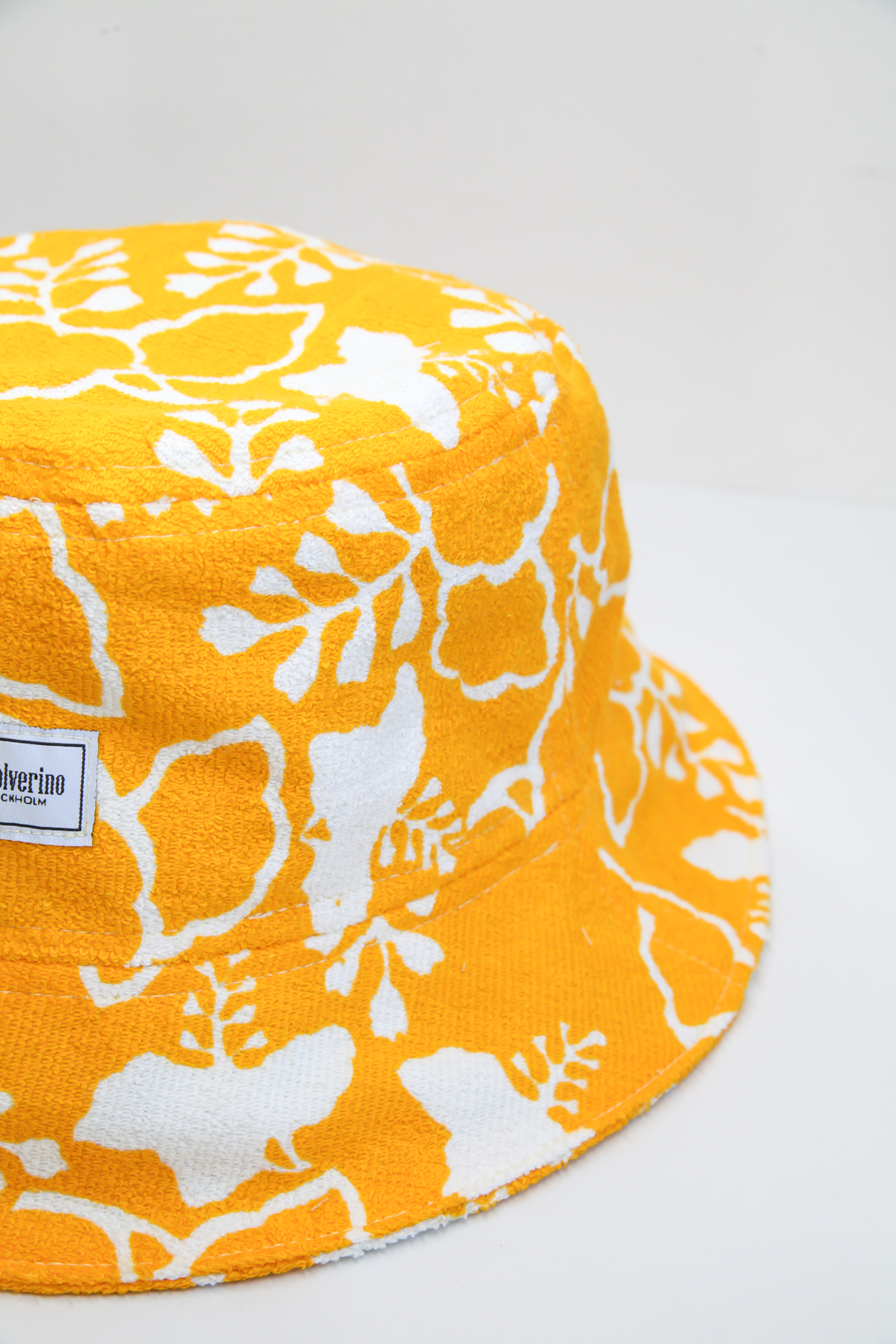 Yellow terry summer bucket hat with white floral tropical pattern