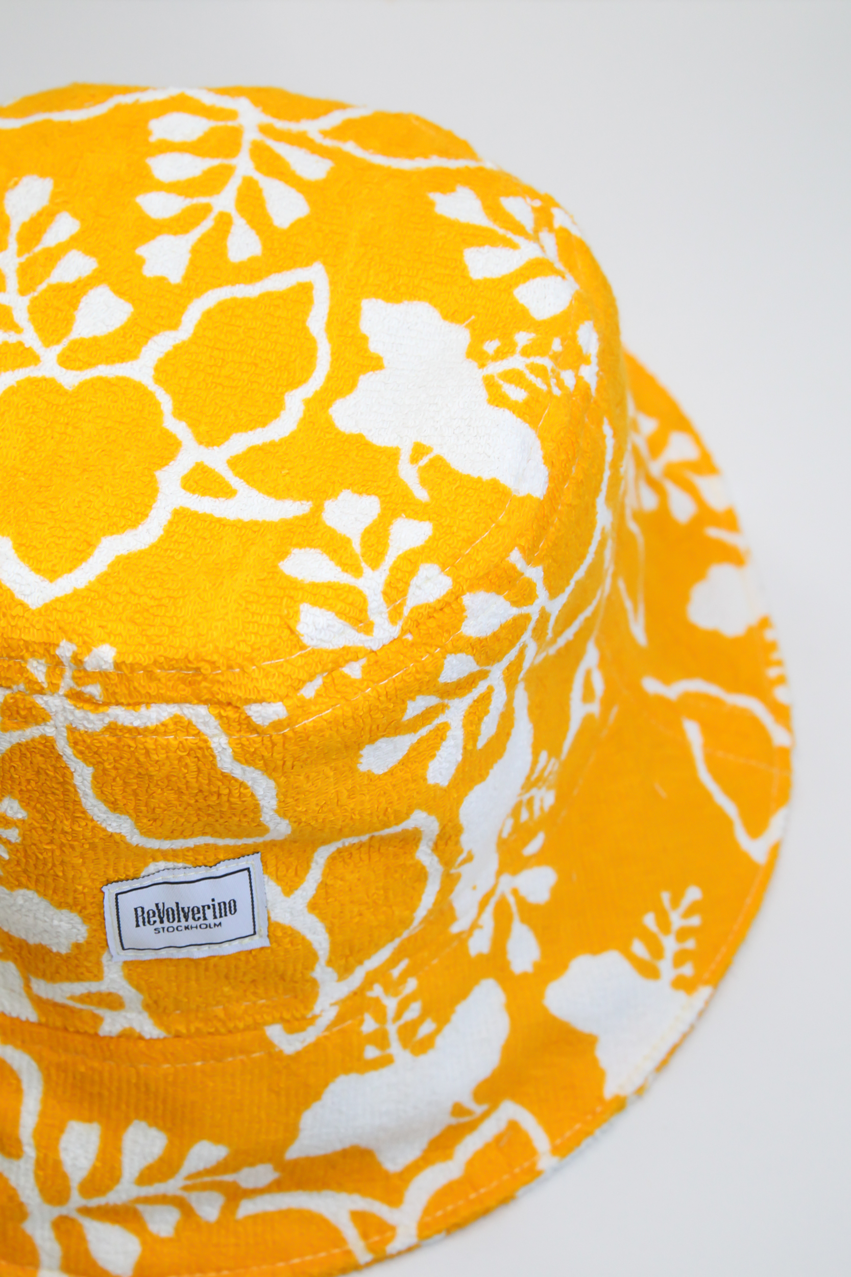 Yellow terry summer bucket hat with white floral tropical pattern