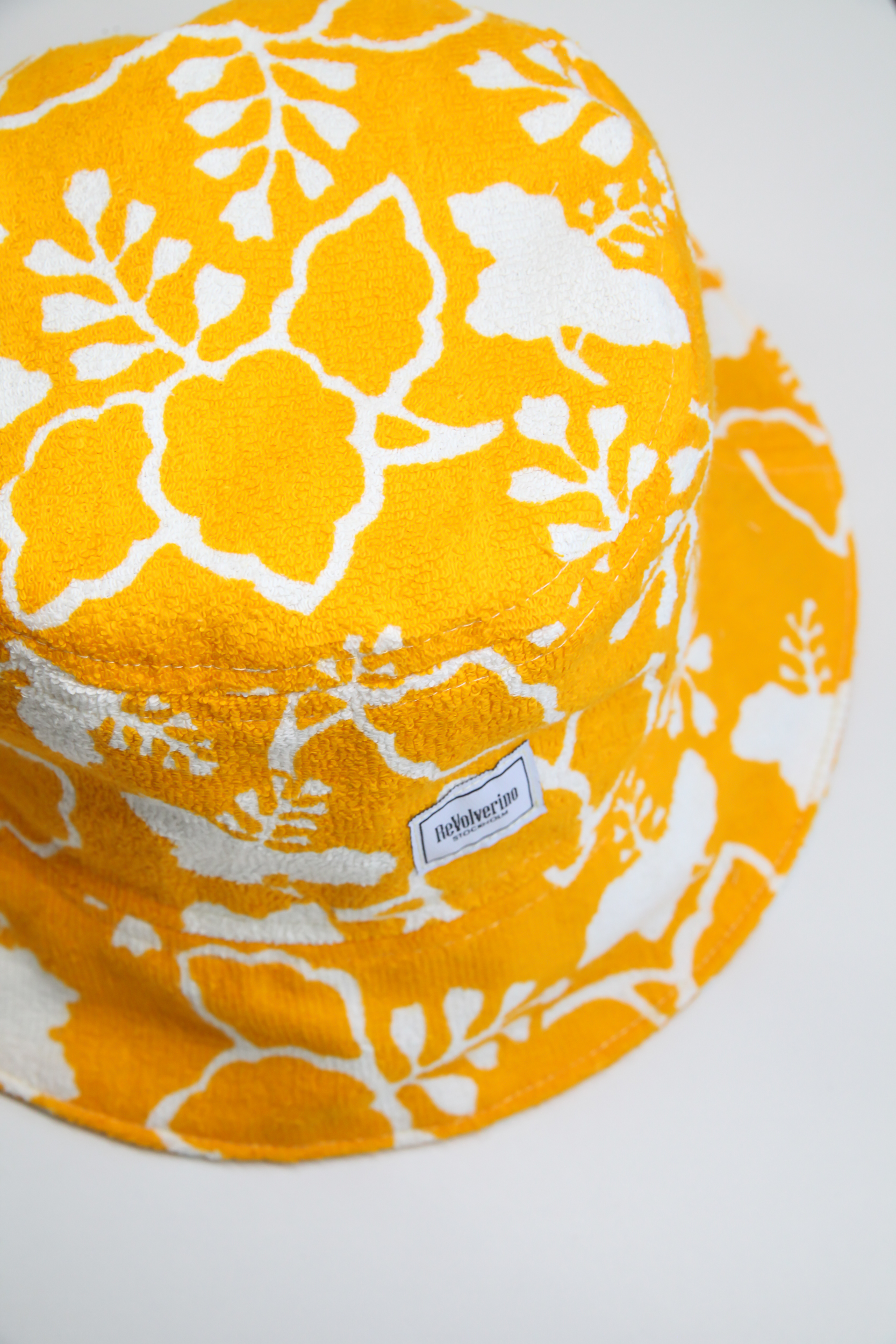 Yellow terry summer bucket hat with white floral tropical pattern