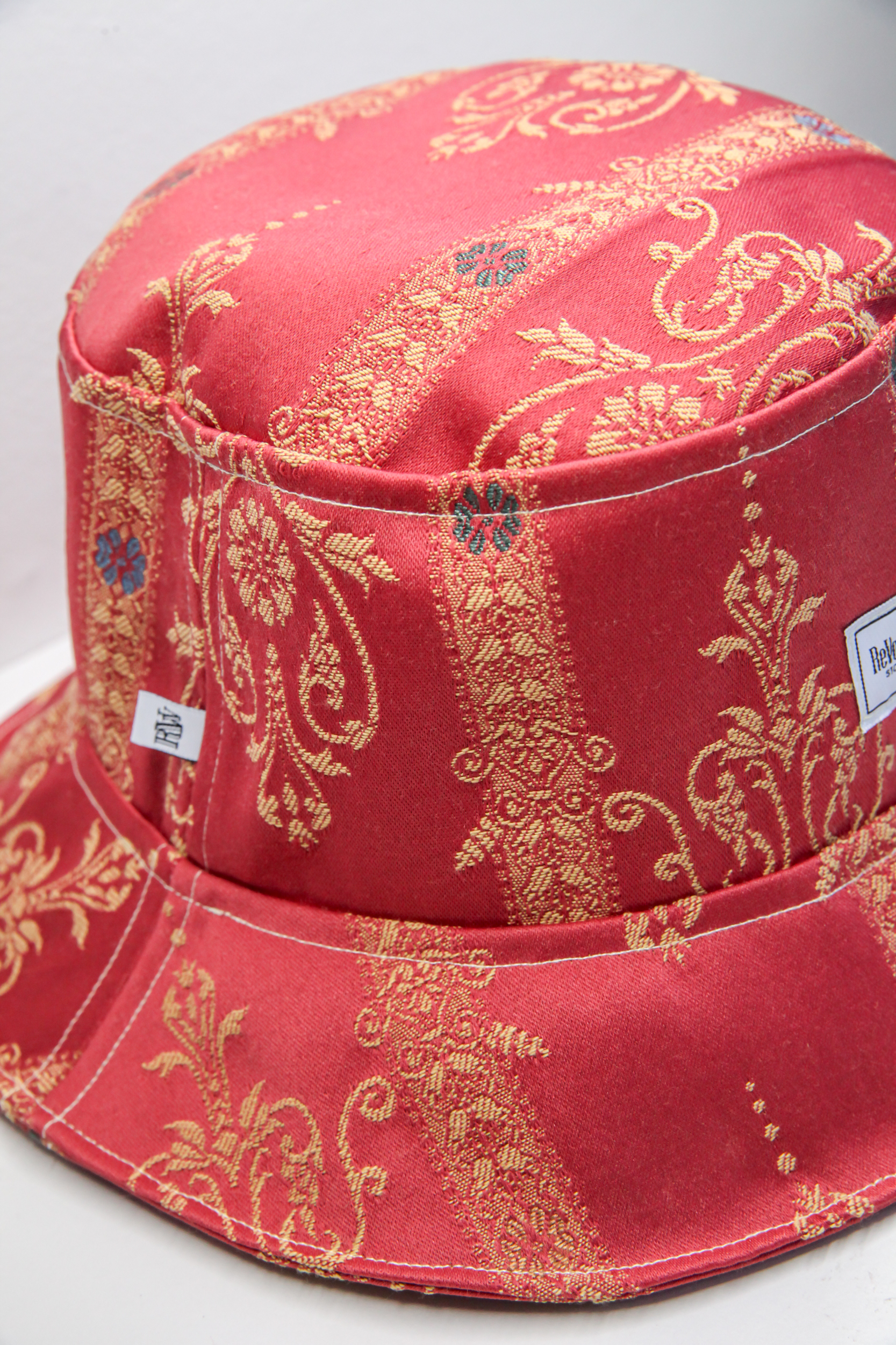 Red classical bucket hat with golden stitched pattern