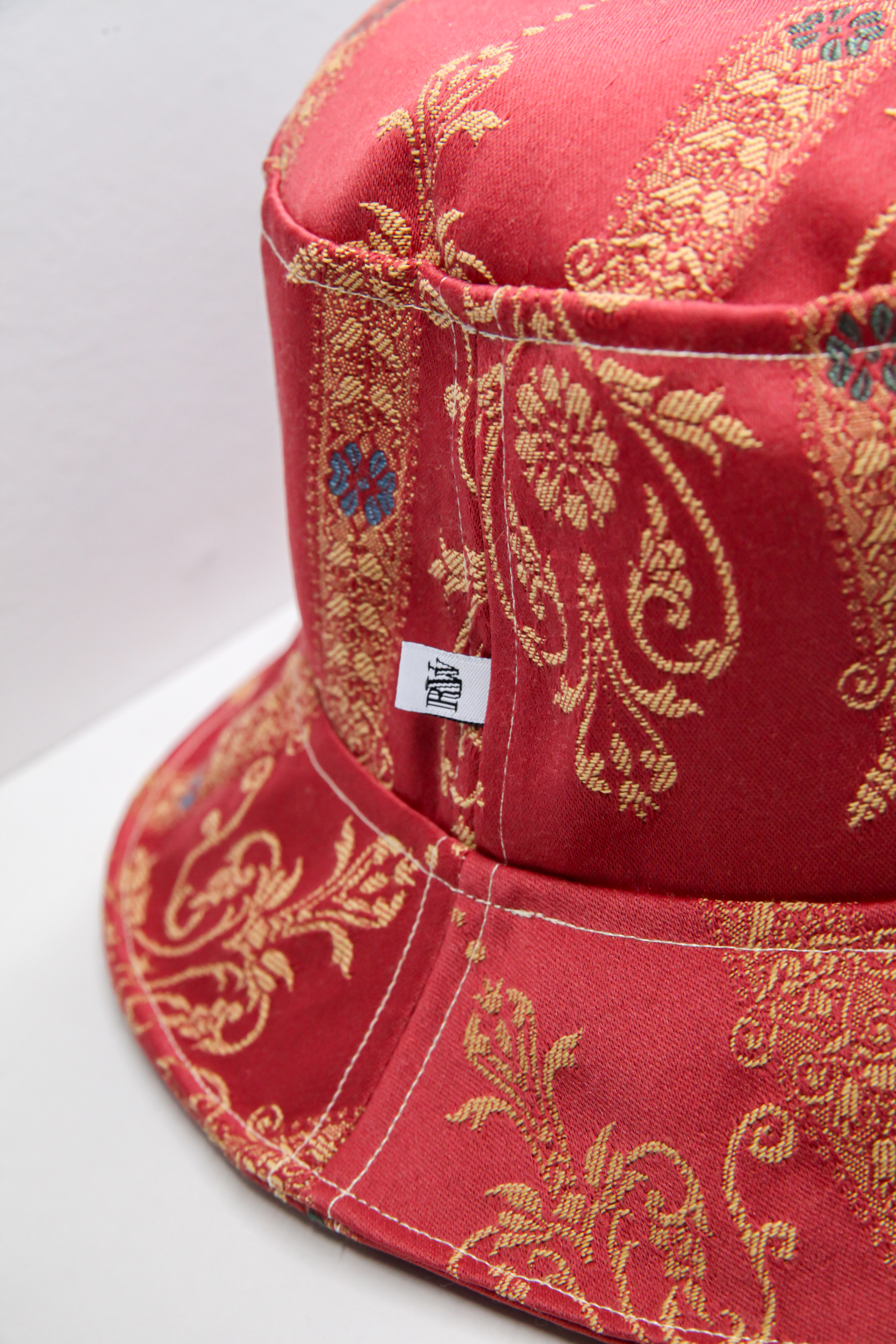 Red classical bucket hat with golden stitched pattern